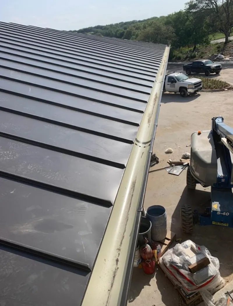 Standing seam panel and gutter detail on a metal roofing jobsite in Knik-Fairview